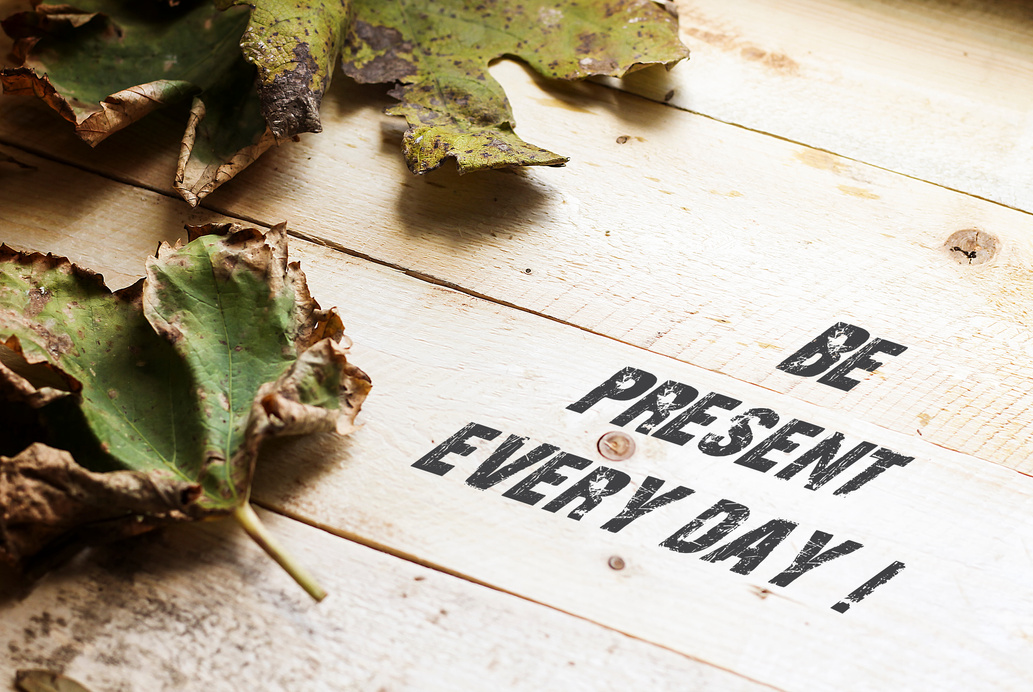 Be present every Day with leafs on wooden table